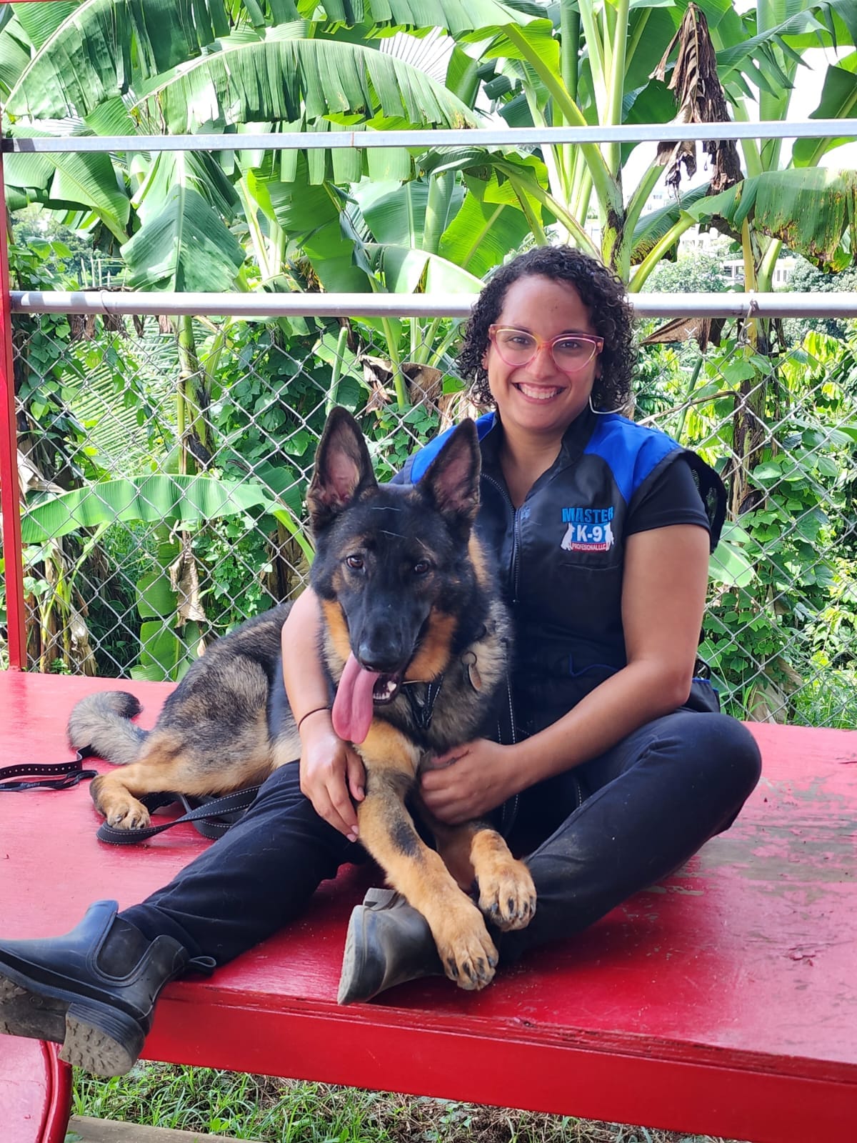 Entrenadora abrazando a un joven pastor alemán