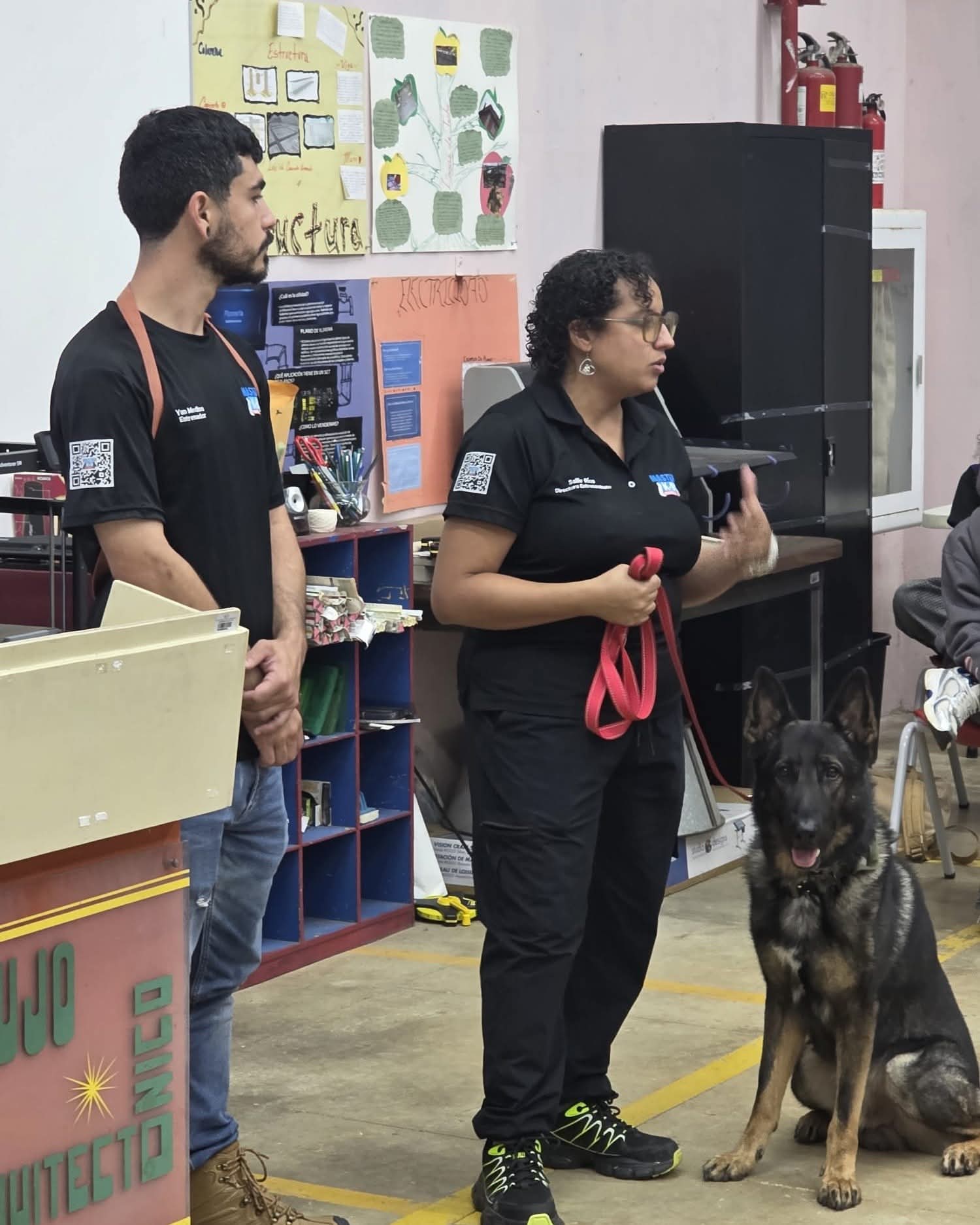 El equipo de Master K-9 en una charla educativa con un pastor alemán