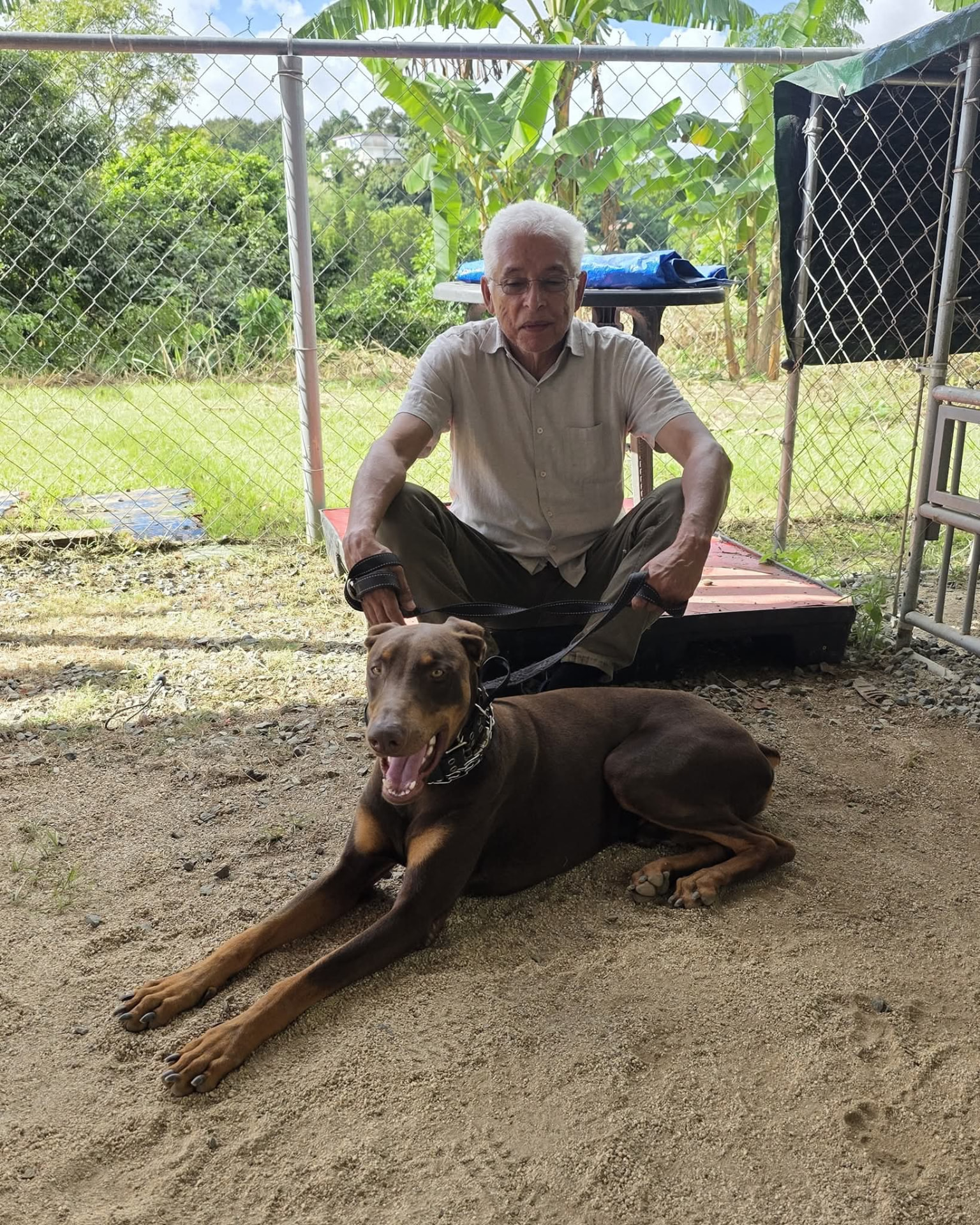 Un señor junto a un Doberman